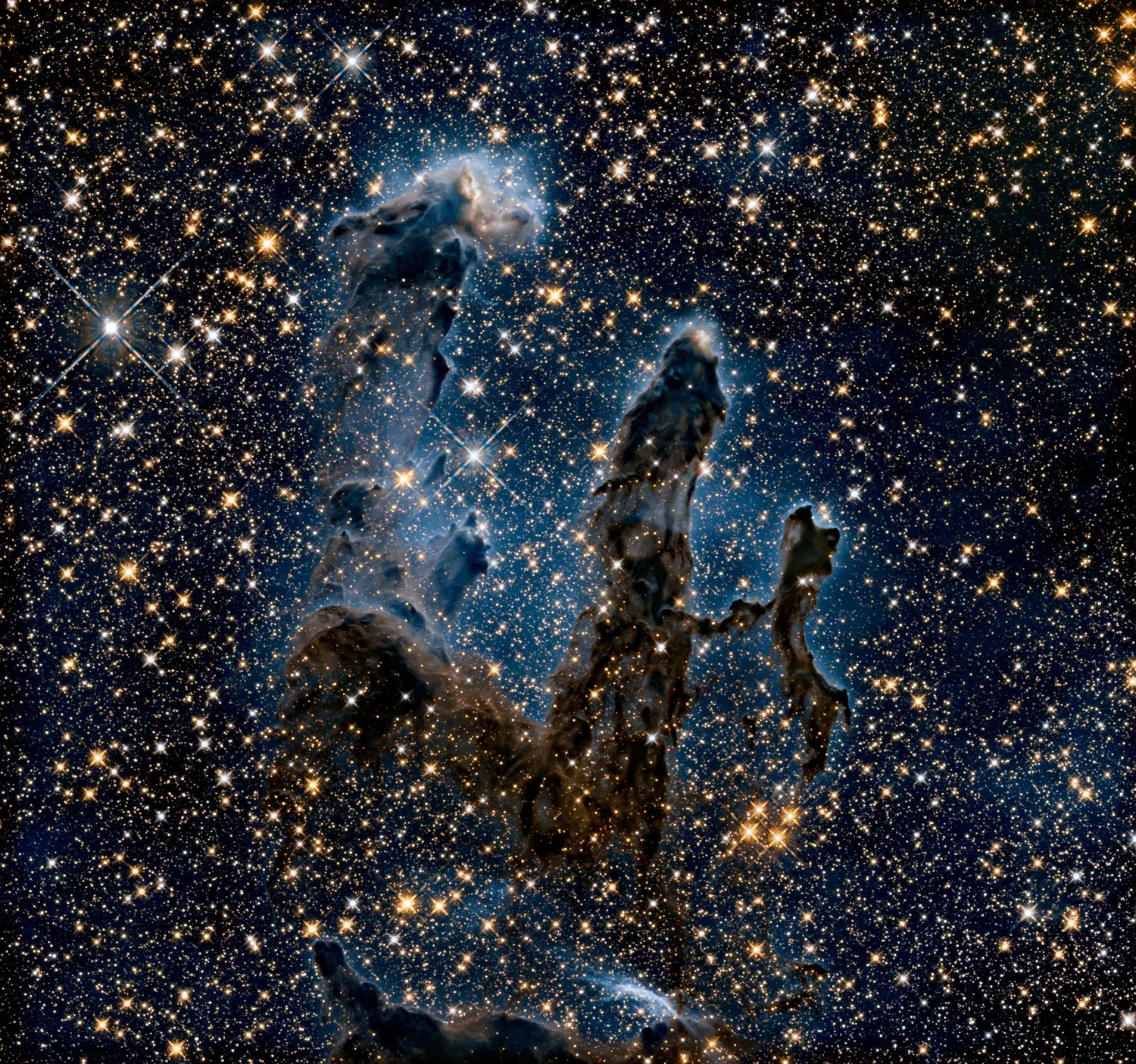 The Pillars of Creation: towering columns of dark dust and gas in the Eagle Nebula, lit from above.